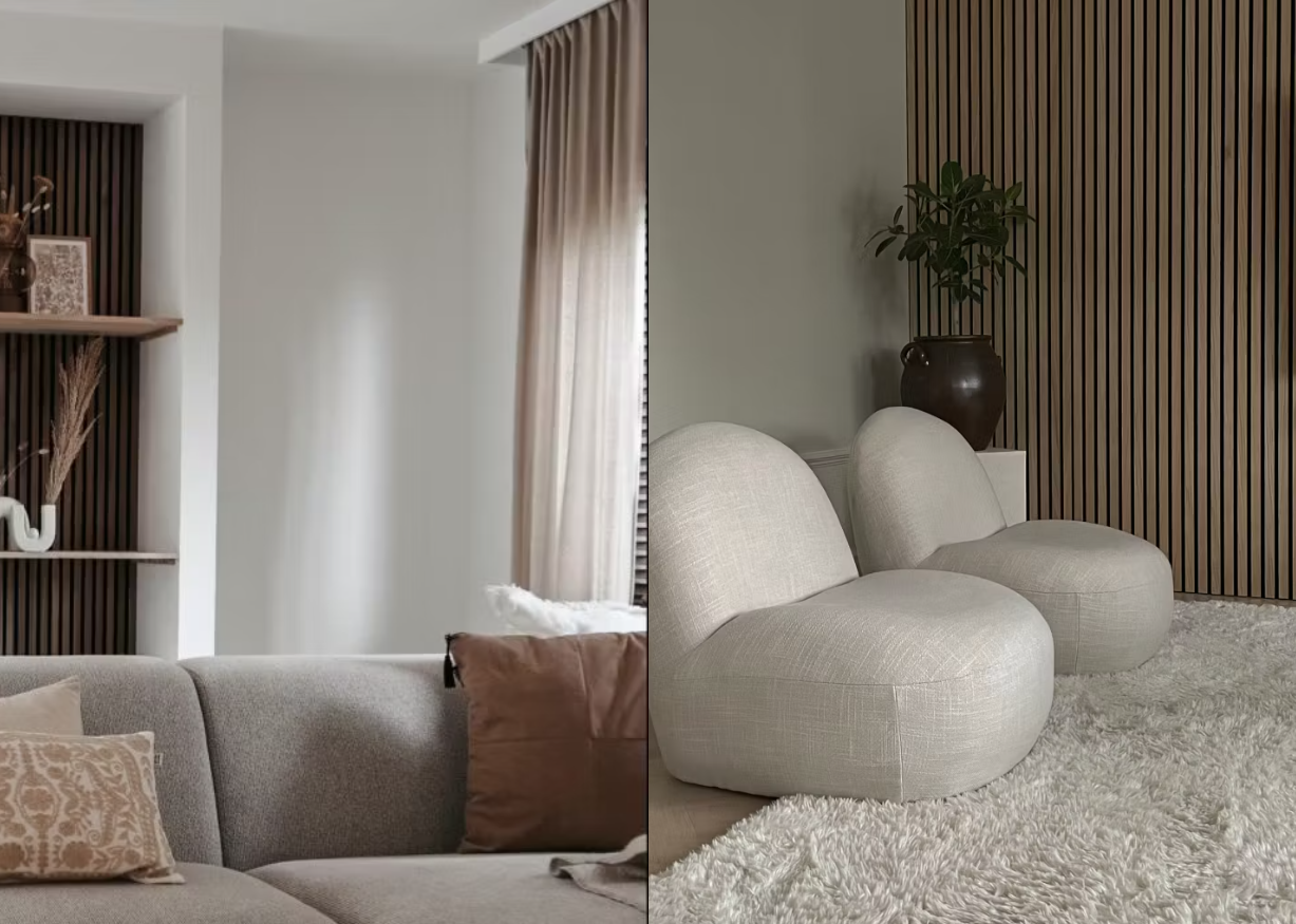 Modern living room with neutral-toned sofas, textured rug, and a wood slat acoustic panel accent wall, illuminated by soft natural light from large windows.